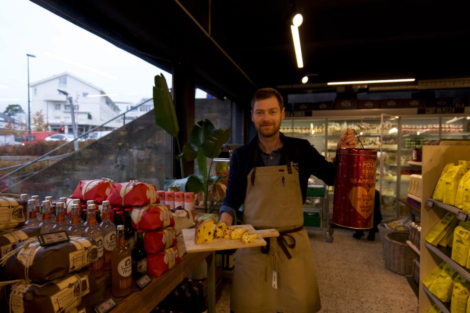 Mann som holder julebrød og tinnboks.