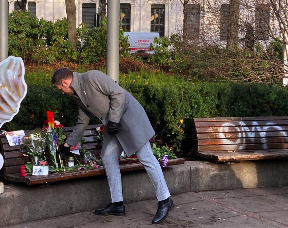 Mann legger blomst på benk