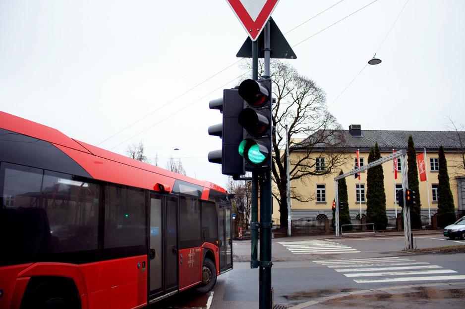 En buss kjører forbi når tafikklyset blir grønt