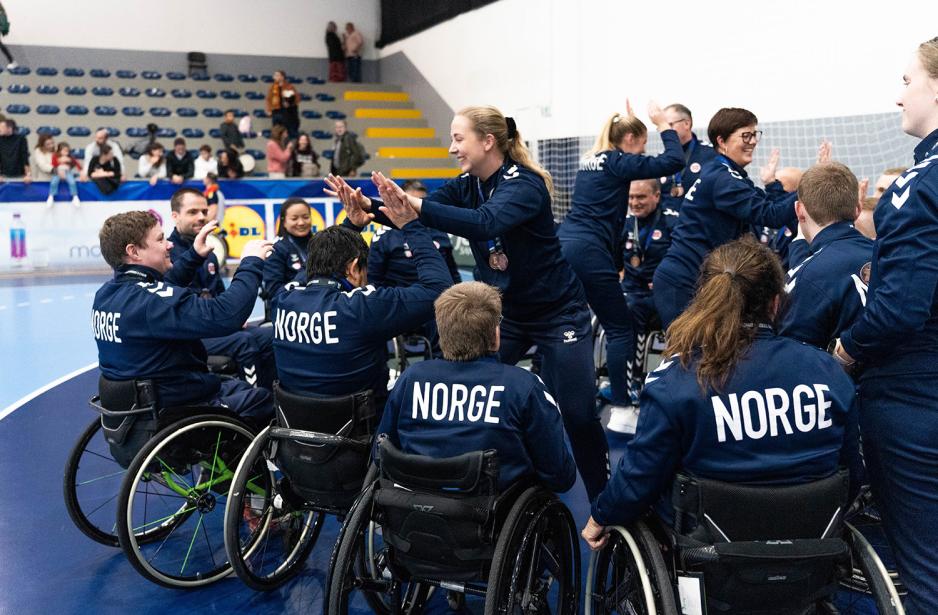 Spillere og trenere tar high five og gratulerer hverandre utpå banen etter bronsefinalen