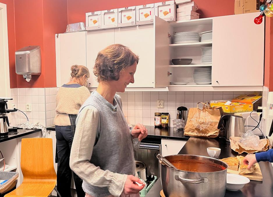 To damer står i en kiosk. De deler ut mat. 