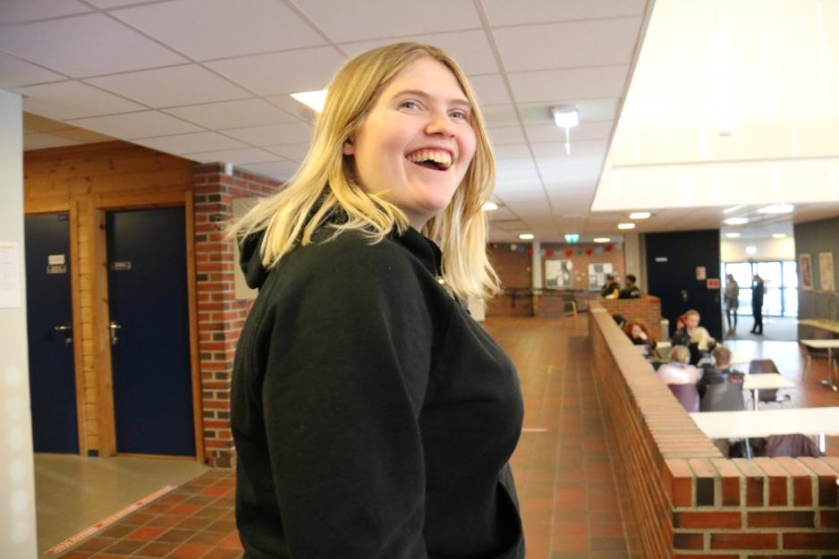 Vera Heide smilende i gangen på Stange videregående skole.