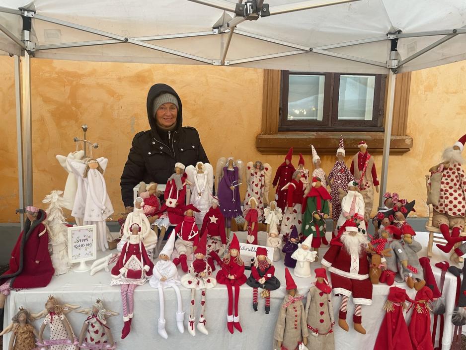 Bildet viser en salgsbod med et utvalg av masse forskjellig julepynt. Her finner man engler og julenisser i mange farger og fasonger. 