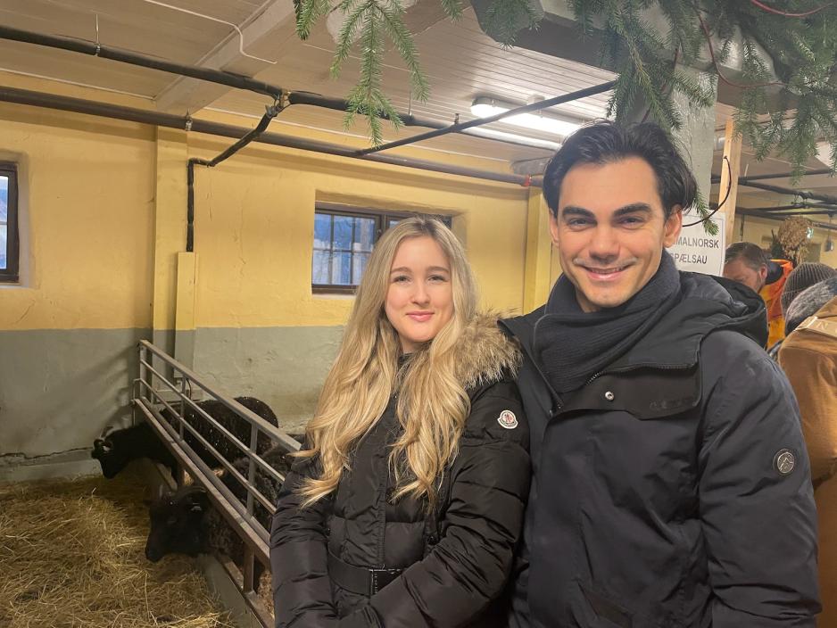 På bildet ser man Janina Lauritsen og Arash Mithraian som er avbildet inne i fjøset på Bogstad Gård. De står foran sauebingen, så i bakgrunnen kan man skimte to svarte sauer.