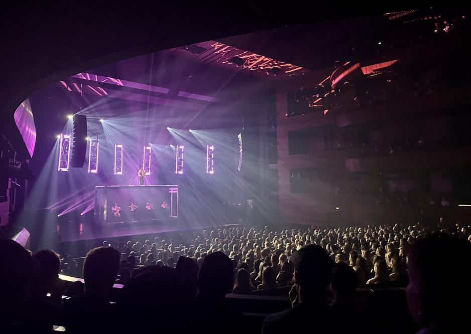 Isah står på scenen inne i hovedsalen i operaen.