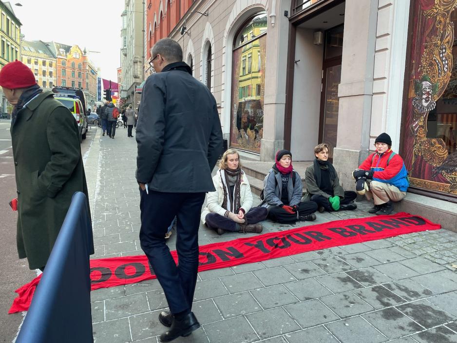 En gruppe demonstranter sitter utenfor Equinor-konferansen.