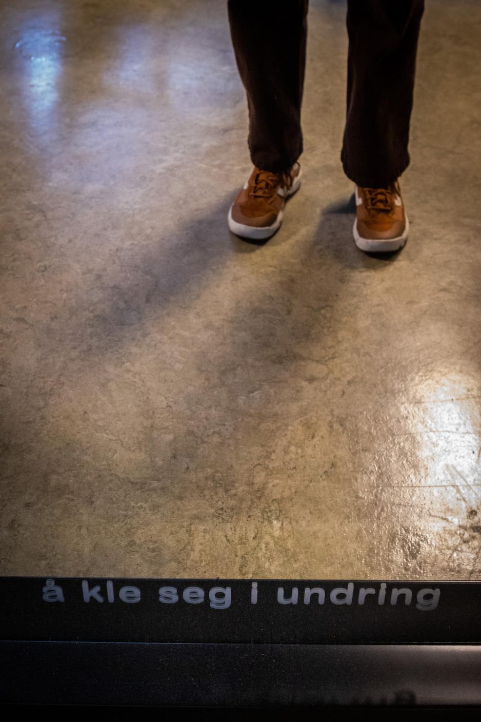 Tekst på et speil. Teksten er "Å kle seg i undring".