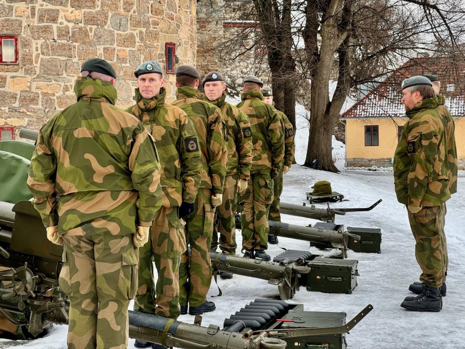 uniformerte menn som står rundt kanoner på Akershus Festning