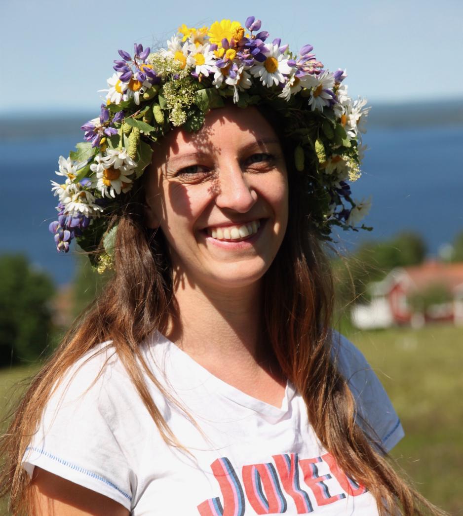 En smilende Hanne Marit Tobiassen med blomsterkrans på hodet