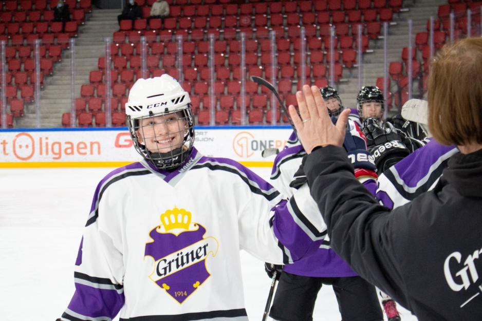 Ishockeyspillere Damer feirer et mål. 