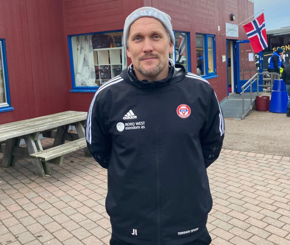 Fotballtrener med hendene bak ryggen