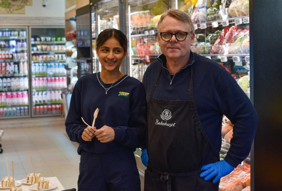 Joker-ansatt og leverandør fra bakerhuset deler ut kake. 