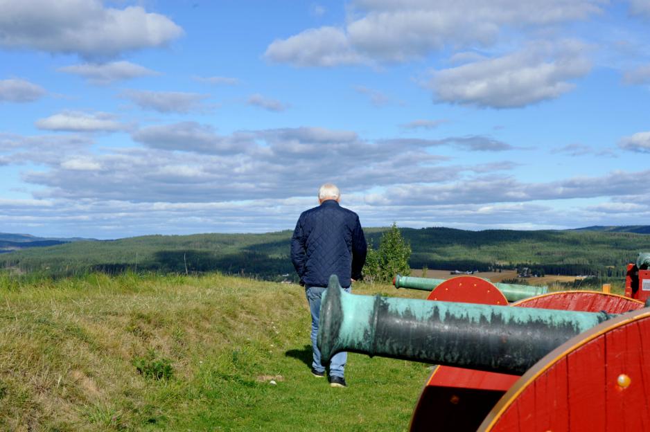 Knut Holen med ryggen til bak en kanon på festningen i Kongsvinger