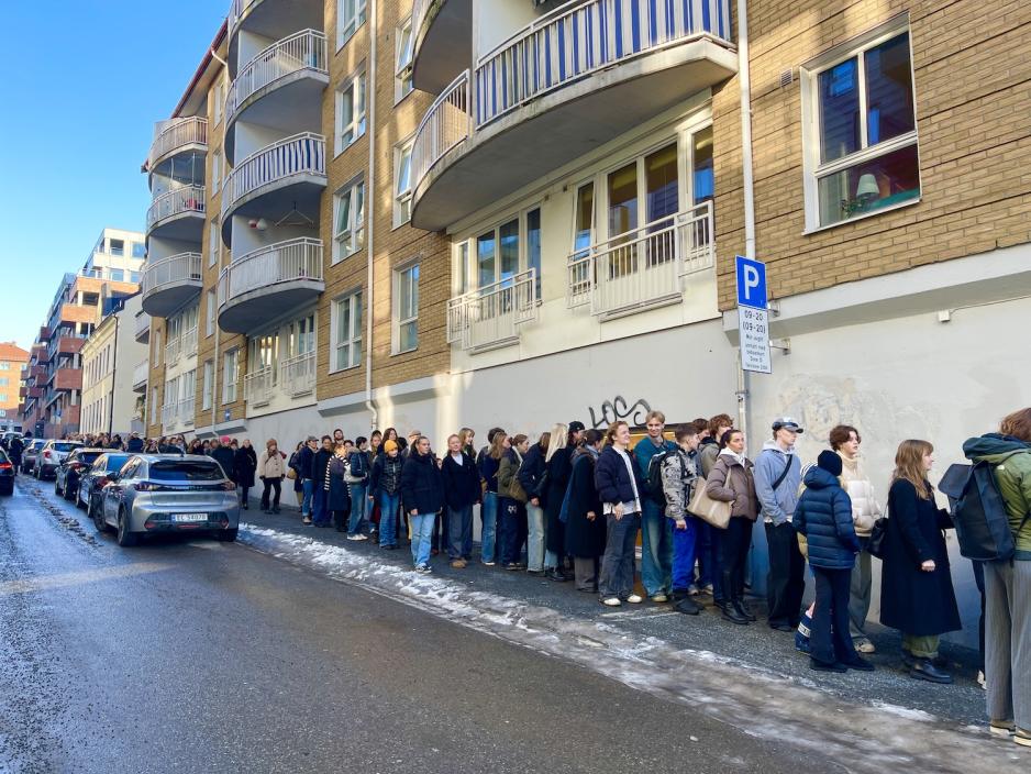 Mennesker som venter på å komme inn i butikken.