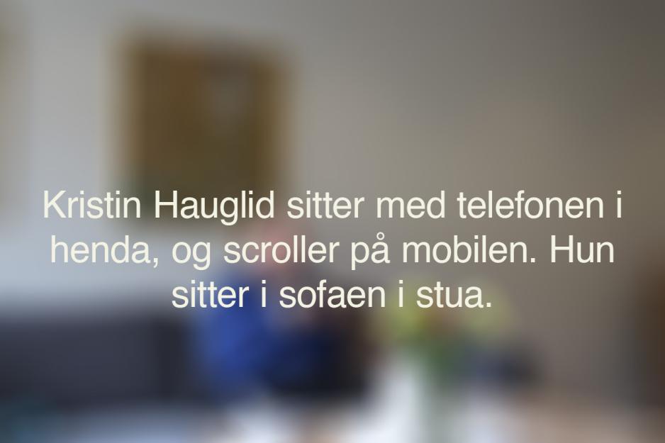 Et uskarpt bilde med den alternative teksten til bildet under. Teksten sier: Kristin Hauglid sitter med telefonen i henda, og scroller på telefonen. Hun sitter i sofaen i stua.