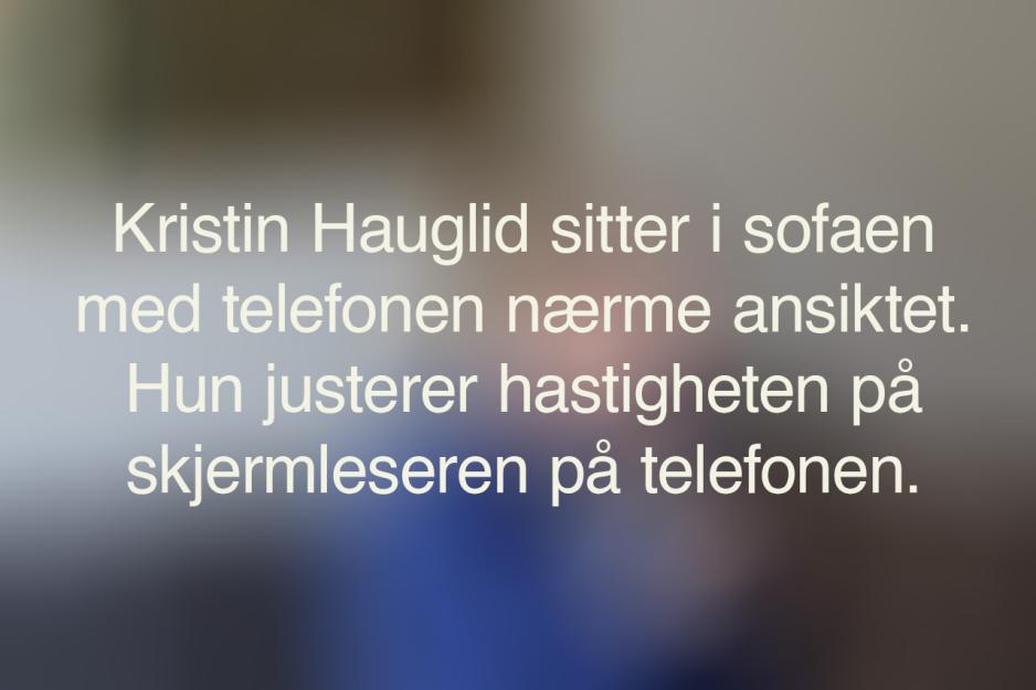 Et uskarpt bilde med den alternative teksten til bildet under. Teksten sier: Kristin Hauglid sitter i sofaen, med telefonen nærme ansiktet. Hun justerer hastigheten på skjermleseren på telefonen.