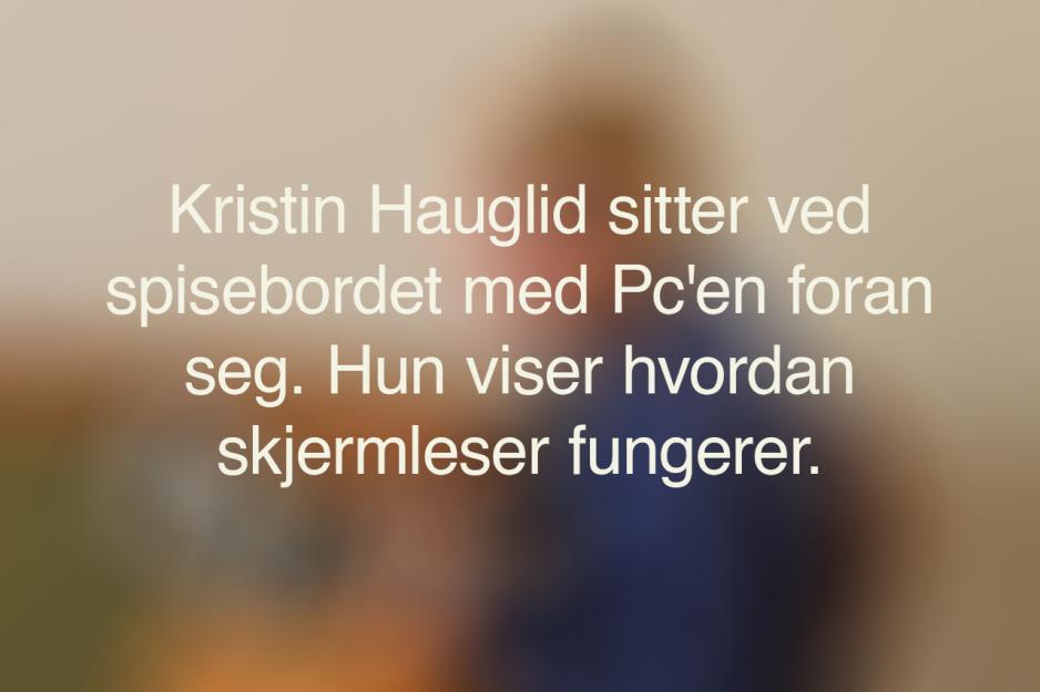 Et uskarpt bilde med den alternative teksten til bildet under. Bildet sier: Kristin Hauglid sitter ved spisebordet med PC'en foran seg. Hun viser hvordan skjermleser fungerer.