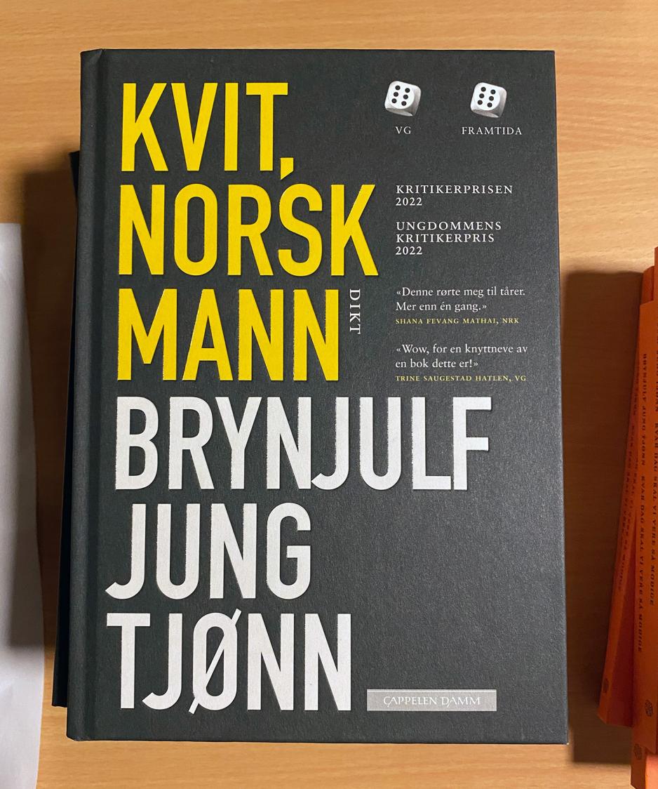 Kvit, norsk mann bok på bord