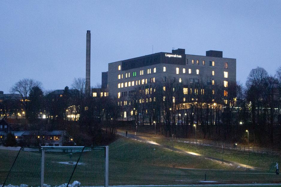 Bygget sett fra trikkestoppet, med lysende bokstaver der det står «Legevakten». Med i bildets forgrunn er en fotballbanet, og bygget ligger på en høyde. Det er mørkt ute.