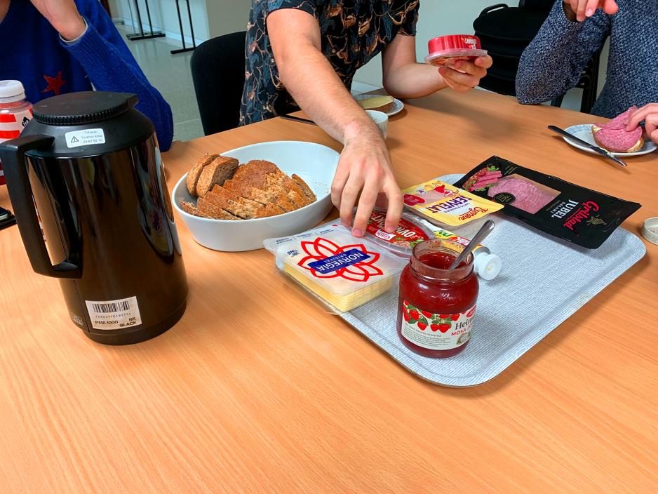 Studentane sit rundt eit dekka lunsjbord. 