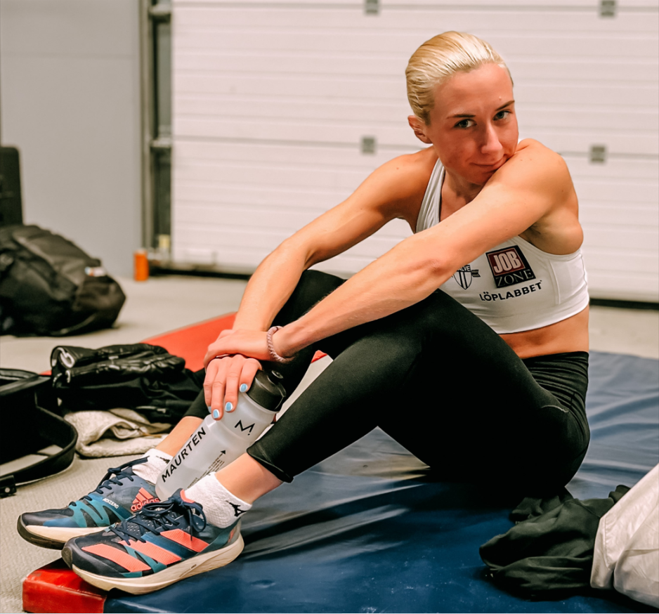 Malin Ingeborg Nyfors sitter på en matte iført treningsklær, mens hun holder en drikkeflaske.