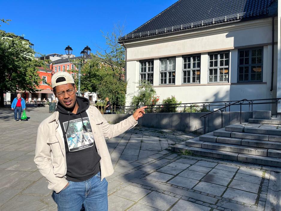 Matias Tunold peker på Deichman Grünerløkka mens han prater.