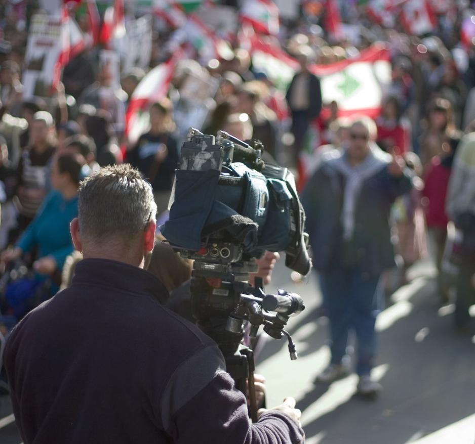 Journalist filmer folk som demonstrerer