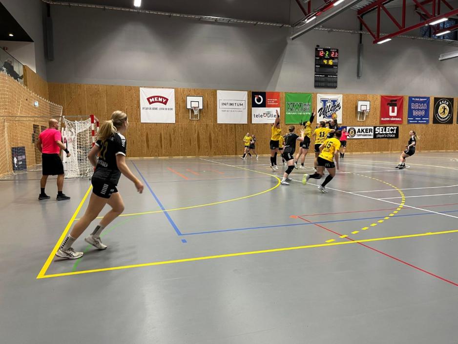 Mange håndballspillere foran et mål. Noen angriper, noen forsvarer