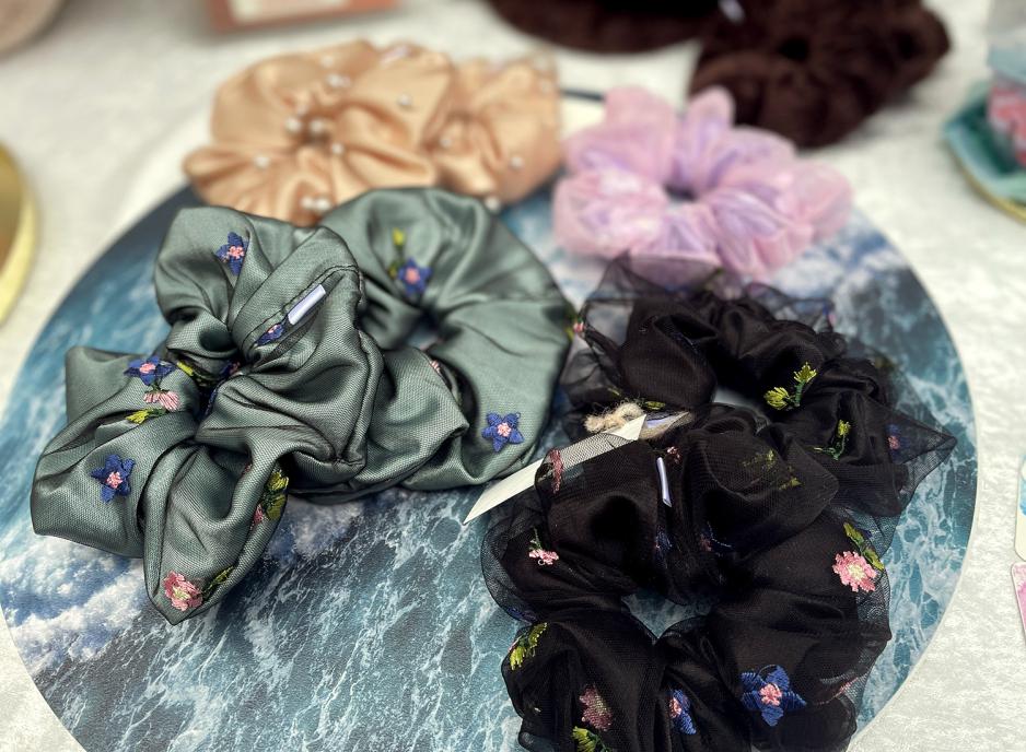 Bildet viser et bord på søndagsmarkedet i Ingensgate med mange scrunchies. Scrunchies er en type hårstrikker. 