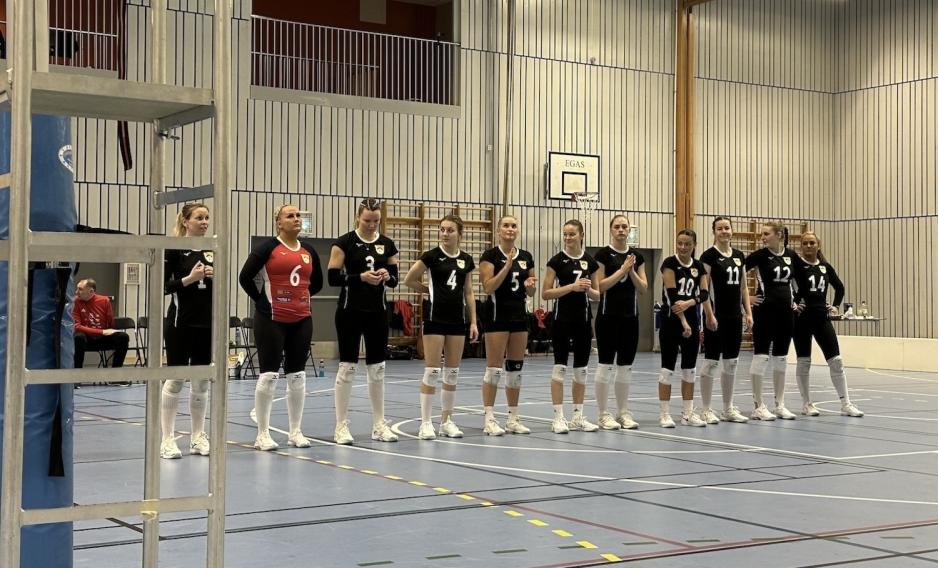 Et volleyball lag som står på rekke i en gymsal