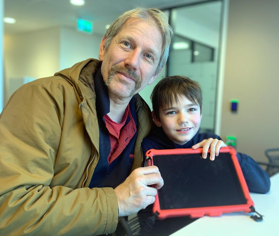 Portrett av Olav og Carl Gabrielsen. Olav i blå genser og Carl i brun jakke. De holder en Ipad