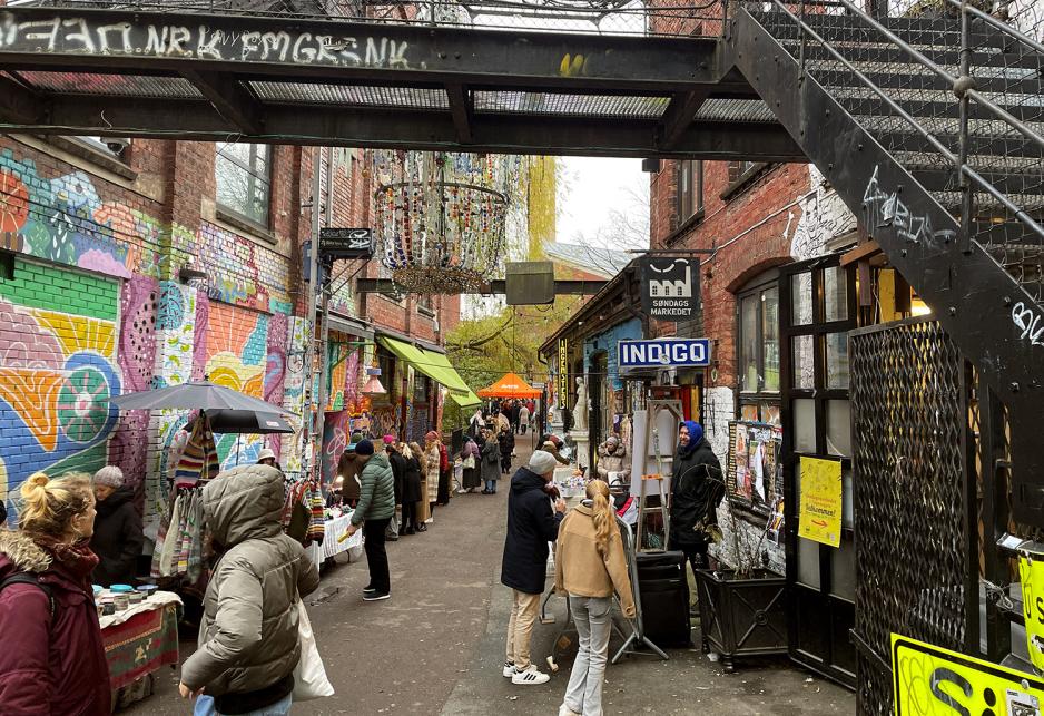 Bildet er tatt mot Ingensgate på Grünerløkka og viser frem livet der på en søndag. Fargerike omgivelser og flere stands. 