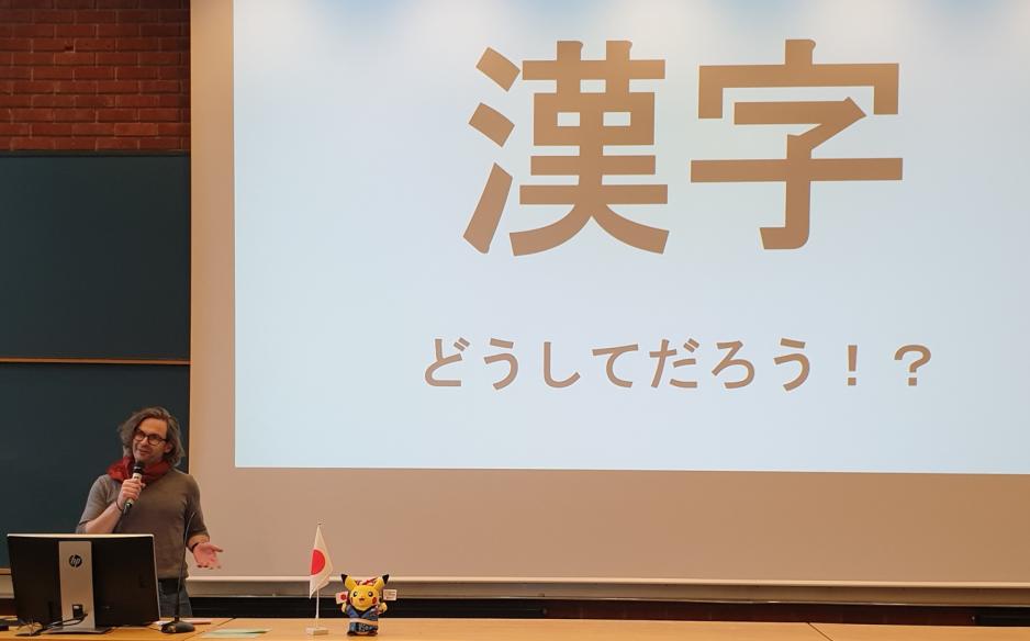 Man står foran en power point med japansk skrift