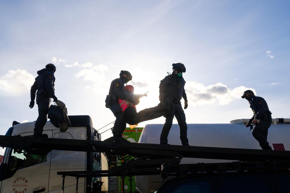 Medlemmer av Beredskapstroppen Delta løfter en demonstrant ned på taket av en panset Toyota Landcruiser.