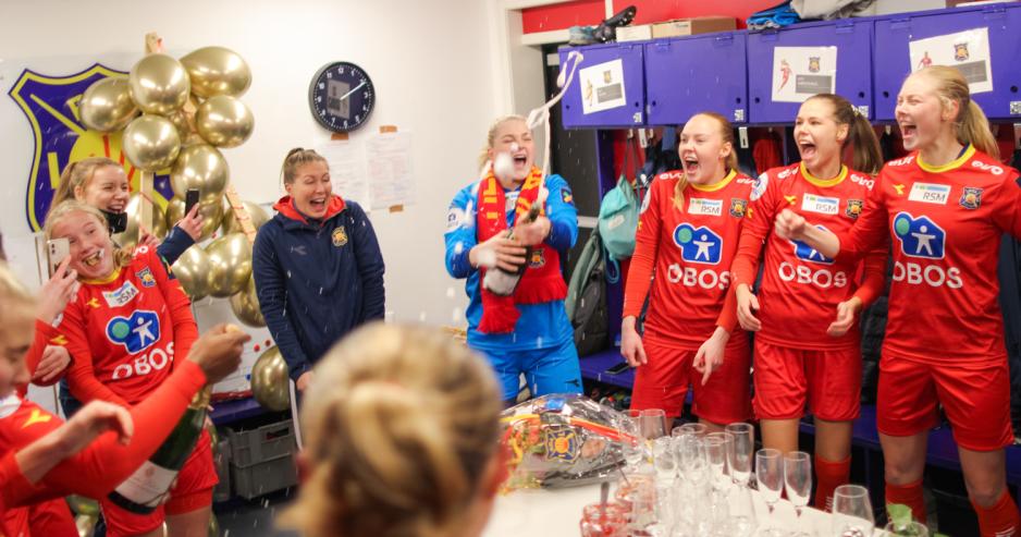 Jentene spretter champagne i garderoben. Folk jubler og er glade.