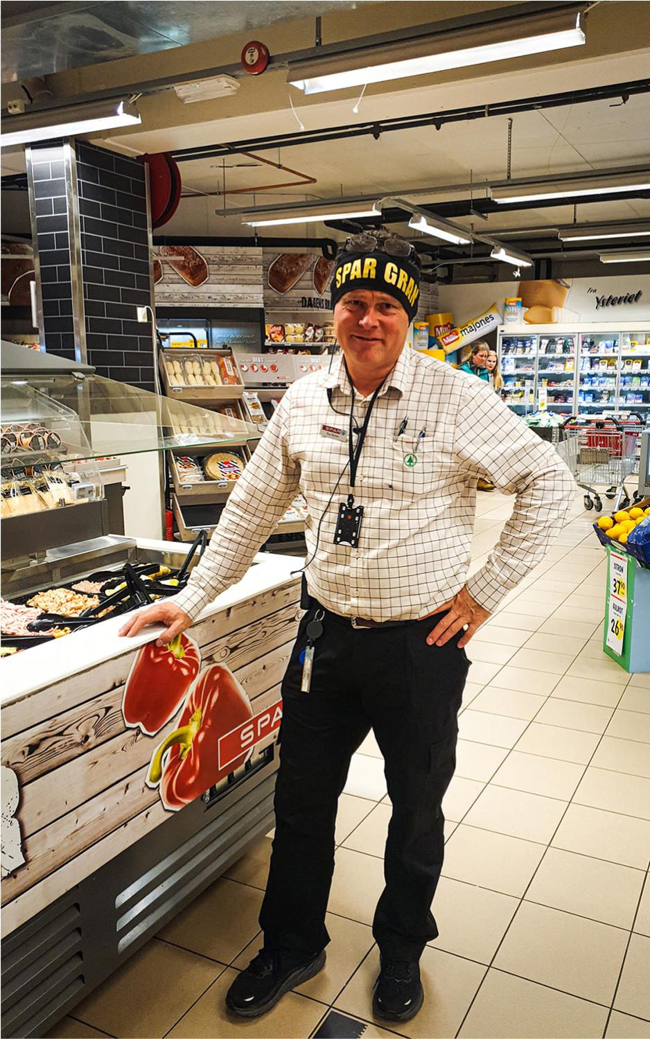 Dagligleder på spar gran, lener seg inntil salatbaren i butikken og smiler. 