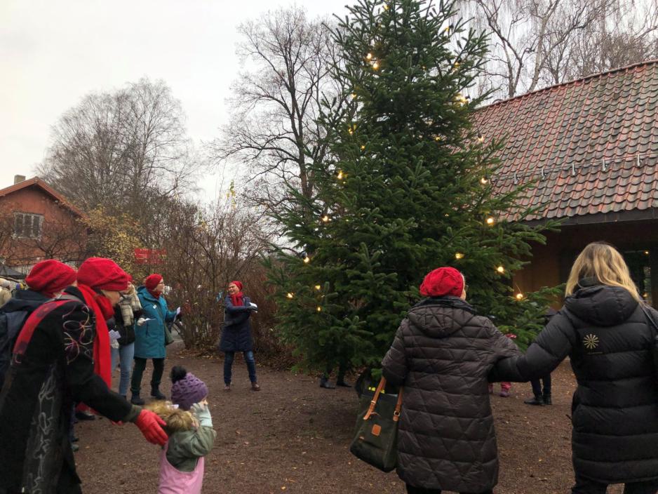 Personer går i ring rundt juletreet