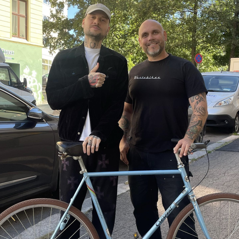 Artisten Unge Ferrari poserer fornøyd etter å ha mottatt en restaurert sykkel fra Wastebikes.