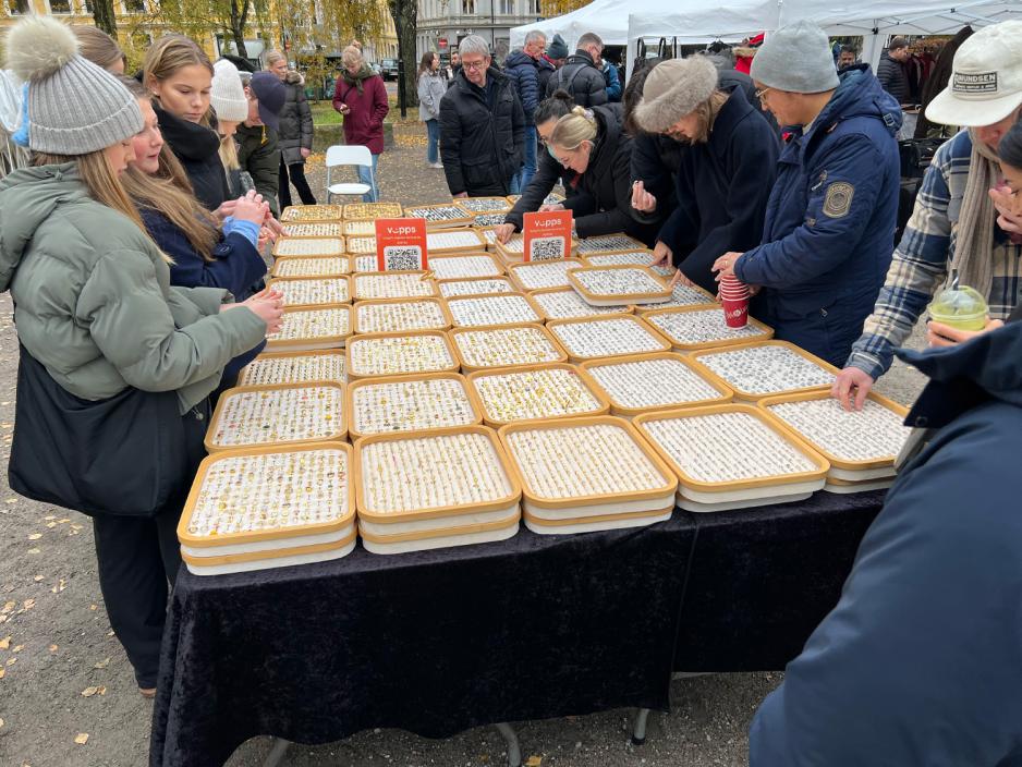 Stort bord med massevis av ringer til salgs, masse folk omkring