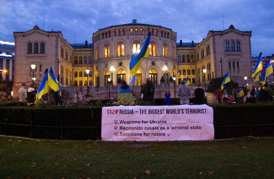 Demonstrasjon utenfor Stortinget, med en stor plakat foran.