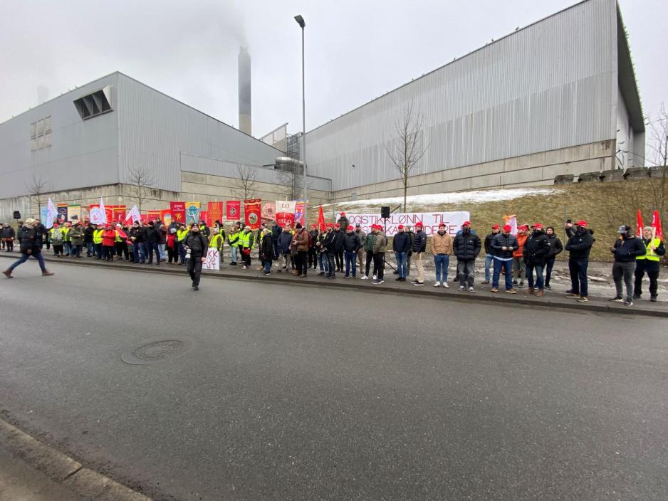 mennesker står på en lang rekke på andre siden av veien