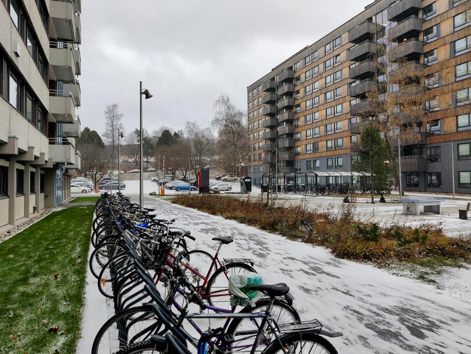 Sykler på stativ og snø på bakken