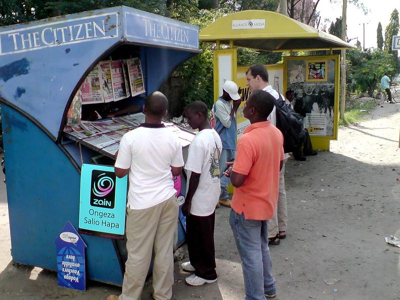 Fem menn står rundt en avisstand for The Citizen i Tanzania. 