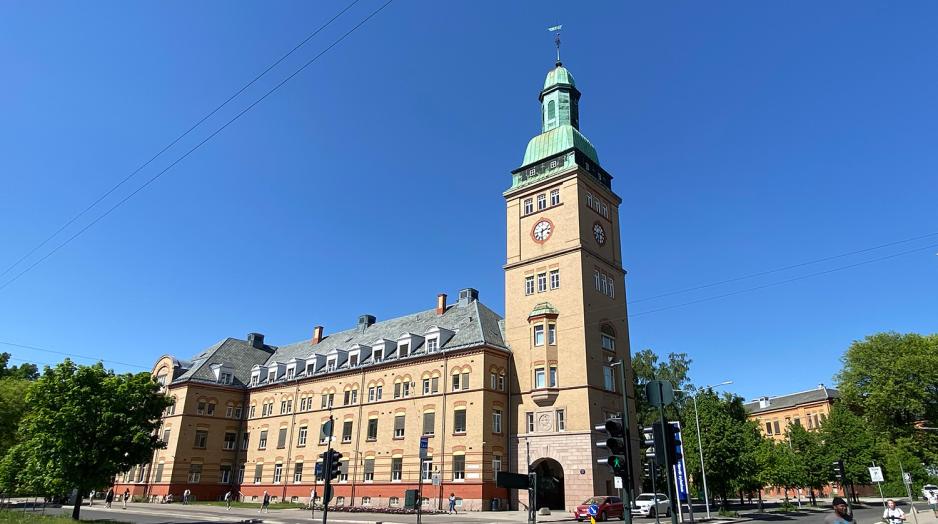 Et av de mest kjente byggene på Ullevål sykehus. Solfylt vær. Bygget er lyst og har grønt tak. 