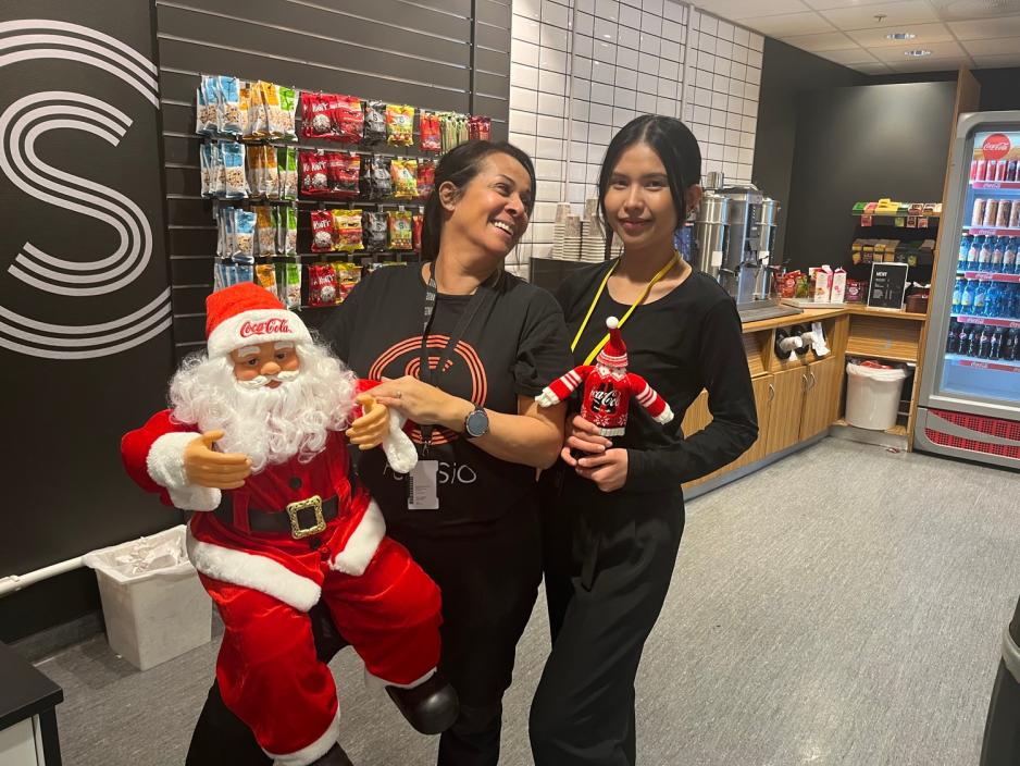 Ziva Engel og Siriporn Siriwal viser fram julenissen de har fått i gave av Coca Cola. 