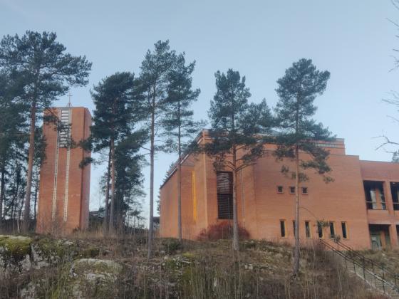 Trær foran en kirke av mur