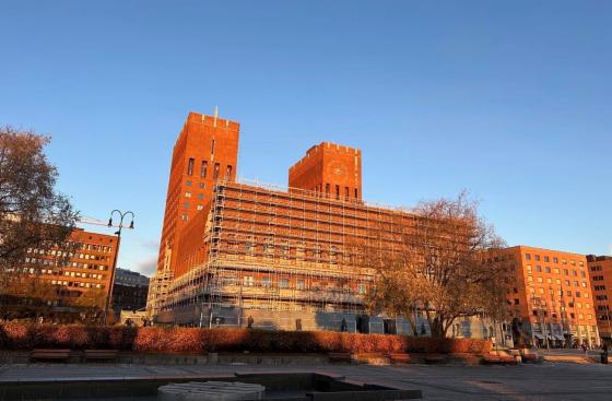 Oslo rådhus. Et stort murbygg med blå himmel i bakgrunn.