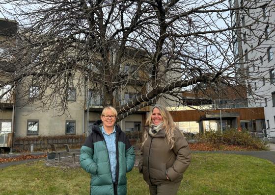 Avdelingsleder og seniorkoordinator foran Grorudhuset og kastanjetreet. 