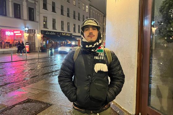 En mann står på gaten og poserer. Han står med hendene i lommen og ser inn i kamera