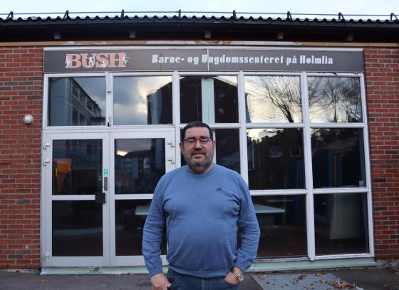 Klubblederen i blå genser foran logoen til BUSH